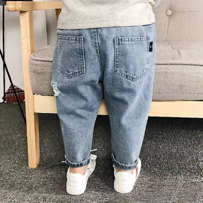 Toddler girl in fashionable ripped denim jeans, comfortable elastic waist, autumn style