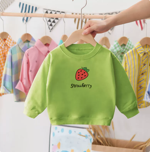 Happy toddler in a red cotton strawberry crewneck sweater, warm winter clothing
