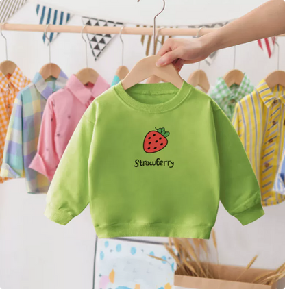 Happy toddler in a red cotton strawberry crewneck sweater, warm winter clothing