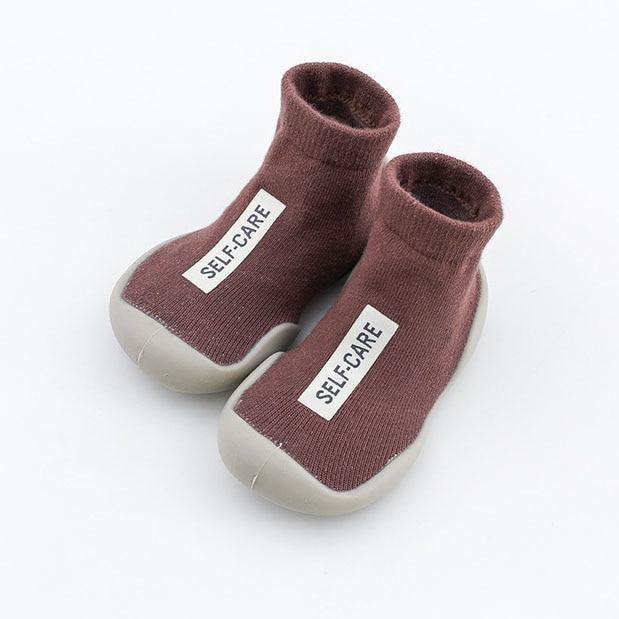 Detail of the non-slip grip on the sole of a toddler's soft sock shoe, safety first