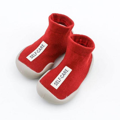 Textured soft-sole sock shoe for toddlers in a light yellow, ideal for home and nursery