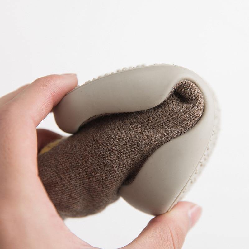 Adorable baby footwear: Cream-colored soft sole sock shoes, gentle on tiny feet