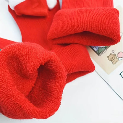 Pair of cheerful toddler anti-slip Santa socks, perfect festive wear for baby's holiday comfort.
