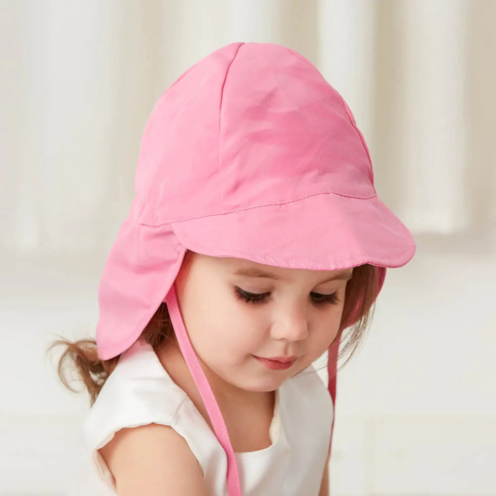 Child smiling while wearing a pink quick-dry UV protection bucket hat, outdoor play