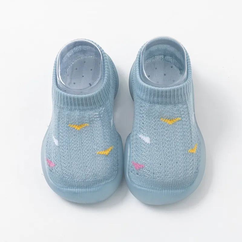 Overhead shot of two pairs of non-slip toddler walking shoes, blue and pink, soft sole.