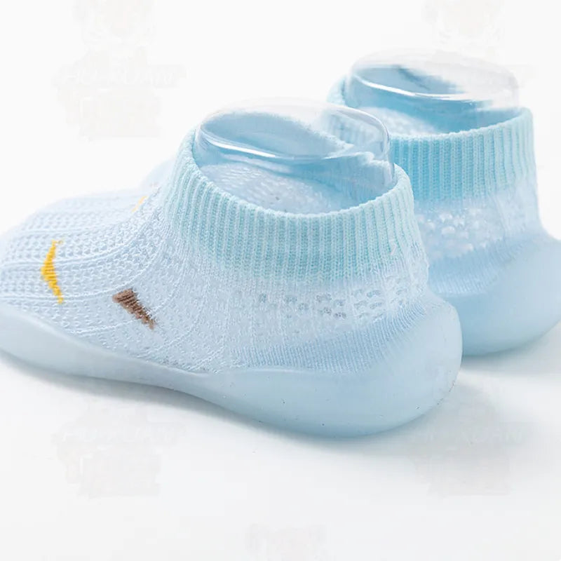 Collection of toddler soft sole non-slip shoes in various colors: grey, pink, blue.