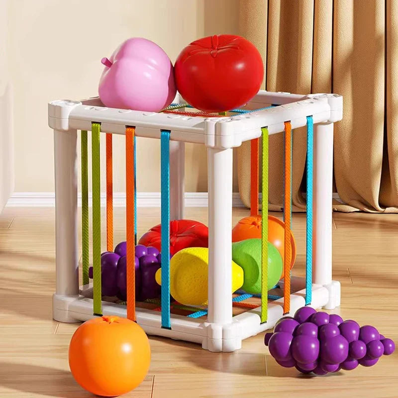 Toddler sorting colorful fruit shapes into an educational wooden box, enhancing motor skills.