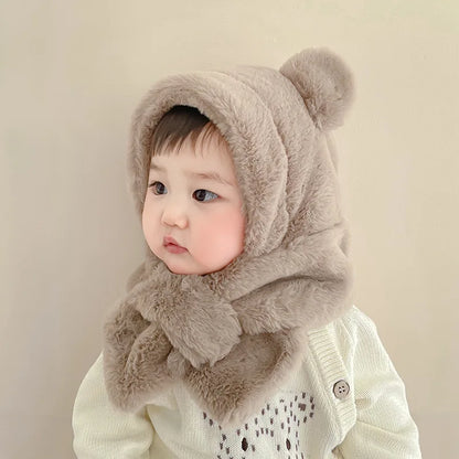 Side view of a happy toddler wearing a warm faux fur bear hat & scarf set, perfect for cold days