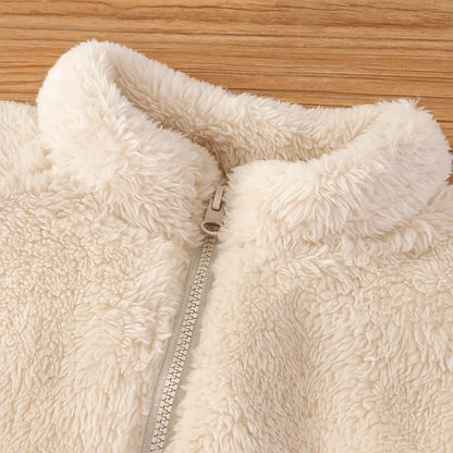 Child smiling while wearing a reversible fleece vest, warm toddler outerwear, playful style