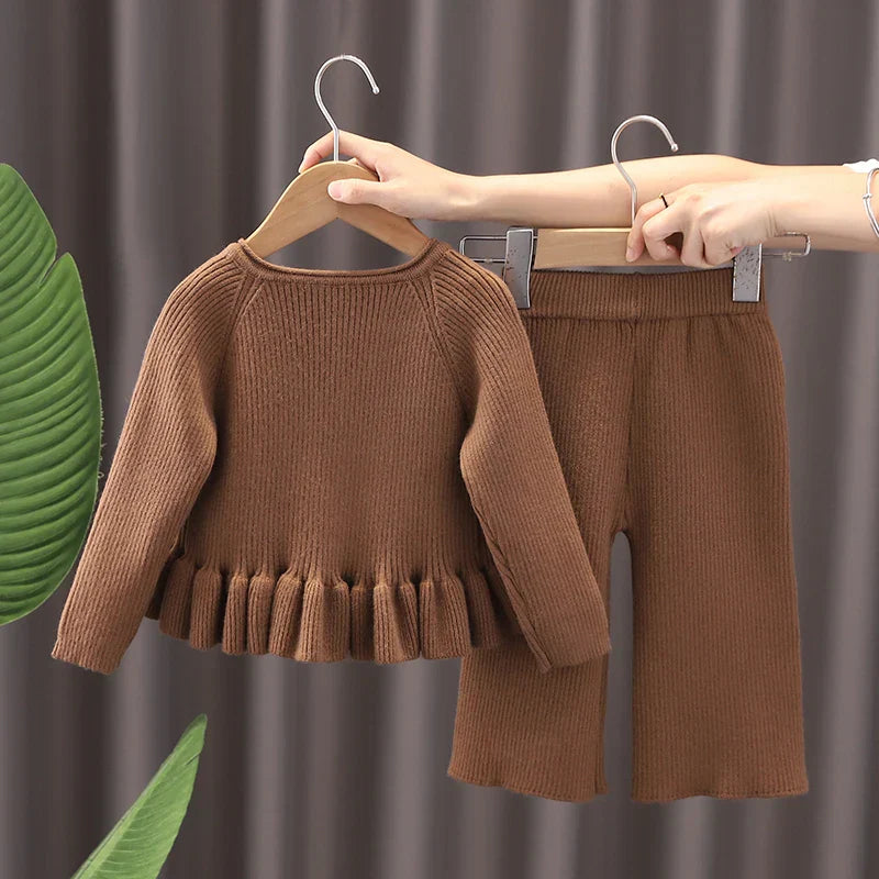 Close-up of a warm toddler bear sweater, knitted fabric with an embroidered bear face