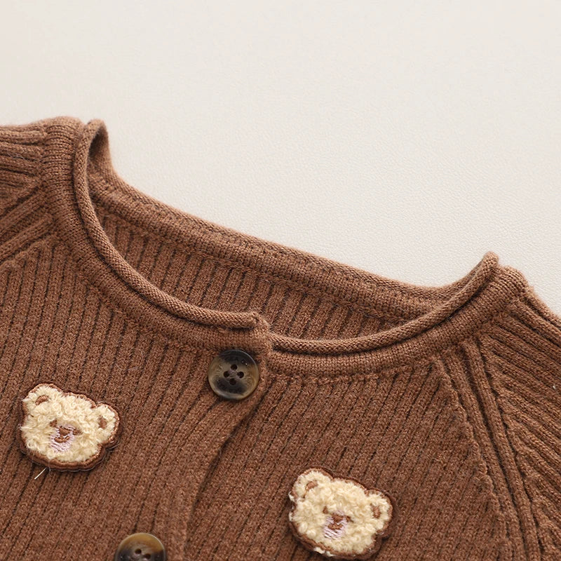Full view of a toddler wearing a bear-themed winter sweater and matching comfy pants