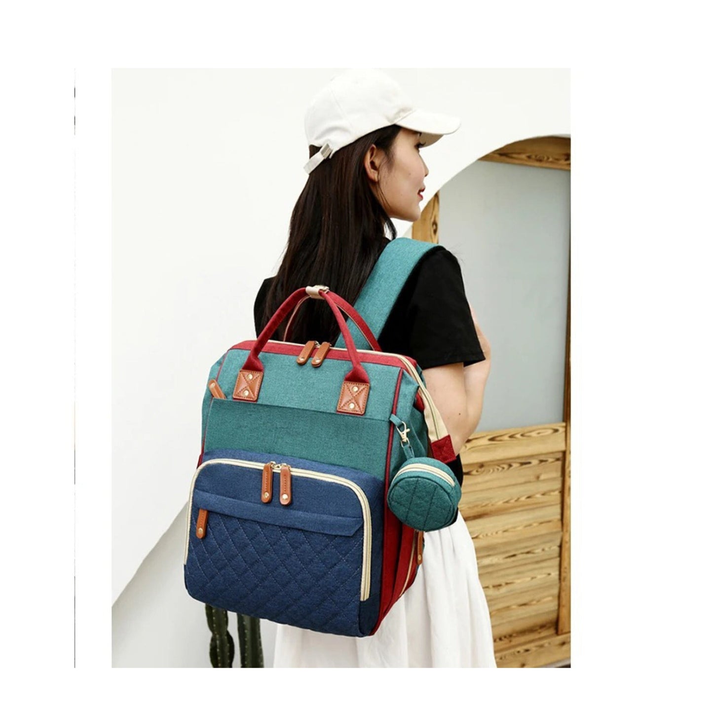 Side view of the travel diaper bag with its integrated portable baby bed unfolded & ready.