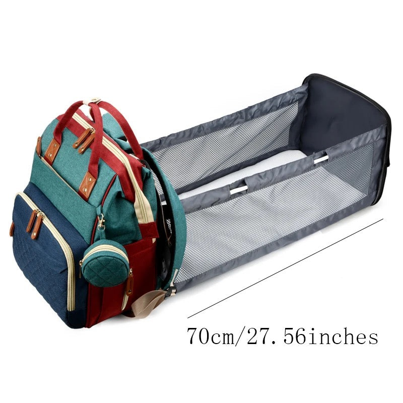 Detailed shot of the portable baby bed within the travel diaper bag, showing soft mattress.