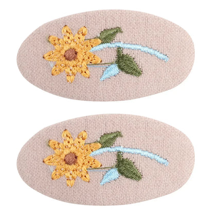 Overhead shot of two retro floral hair clips, simple yet elegant design
