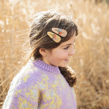 A pair of vintage-inspired floral hairpins, perfect for kids' party accessories