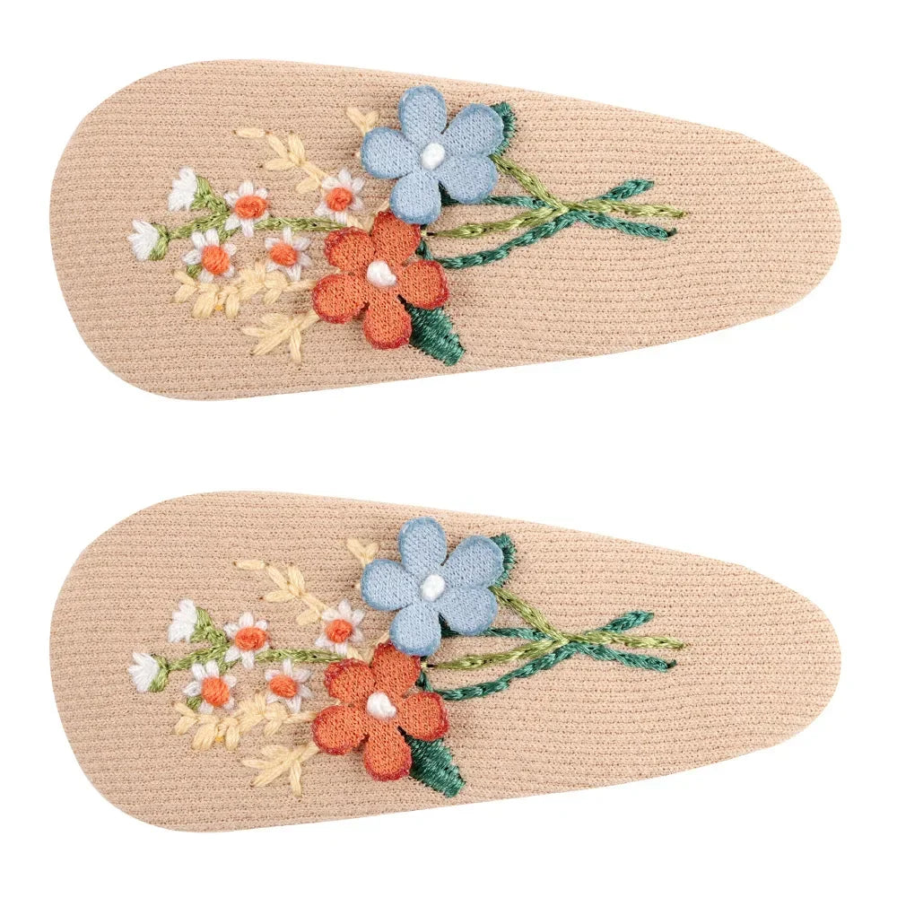 Close-up of a retro floral hair clip, highlighting vibrant colors and detailed design
