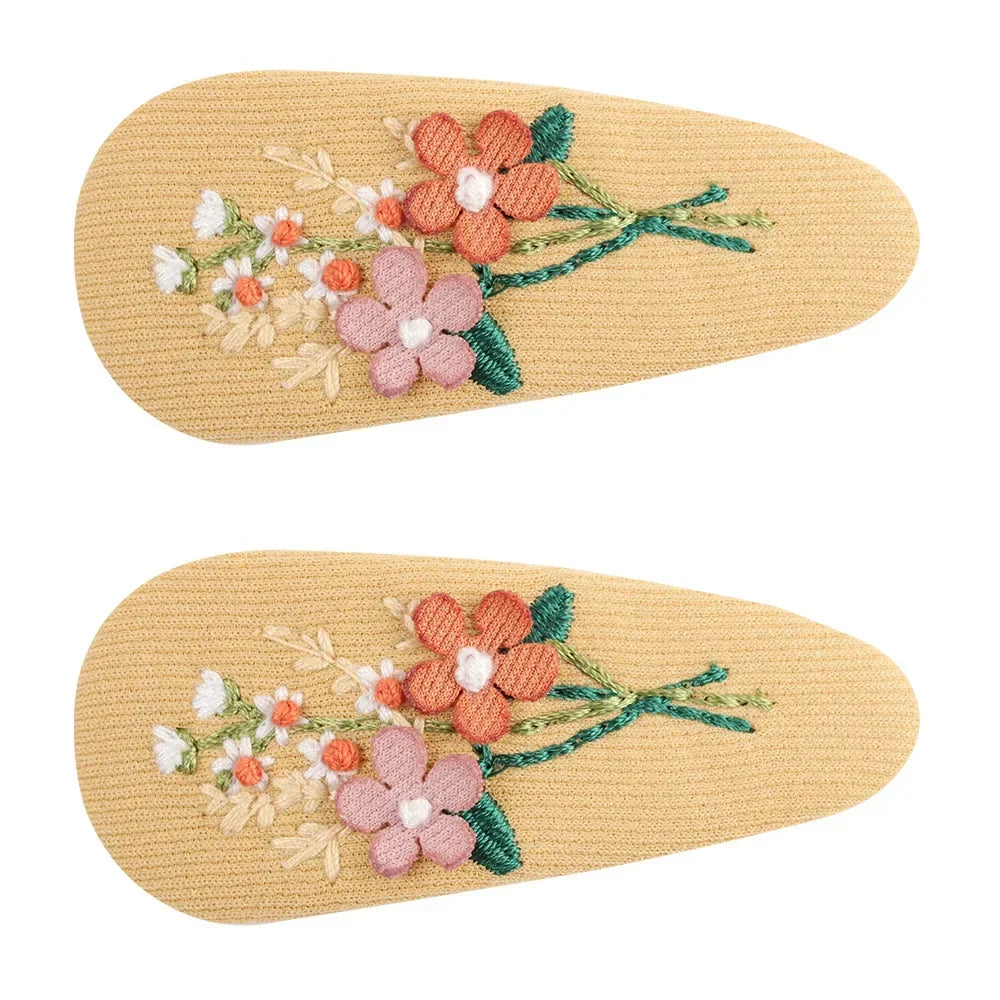 Retro floral hair clip on a model, demonstrating its size and placement in kids' hair