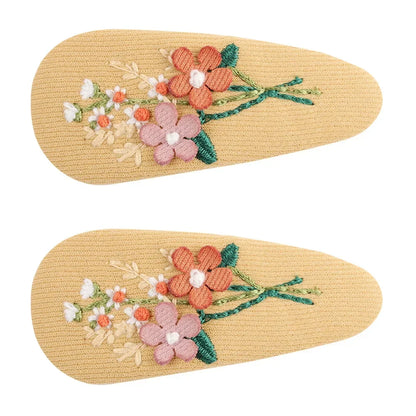 Retro floral hair clip on a model, demonstrating its size and placement in kids' hair