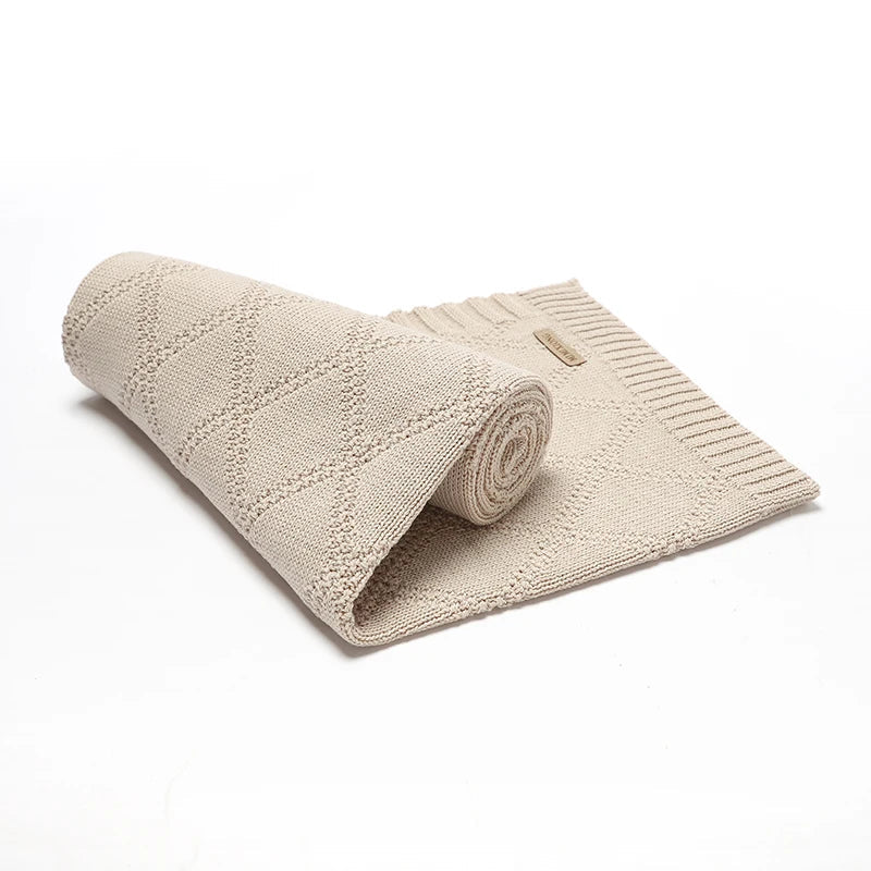Folding shot of a grey cotton swaddle blanket with 'sweet dreams' embroidery, a thoughtful baby shower gift