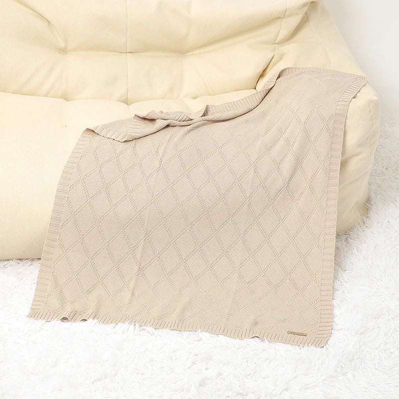 Organic cotton baby blanket draped over a crib, enhancing nursery decor & providing infant comfort
