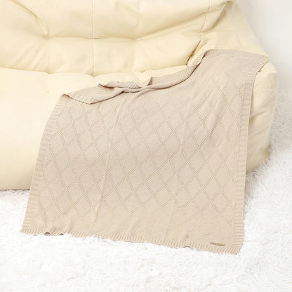 Organic cotton baby blanket draped over a crib, enhancing nursery decor & providing infant comfort