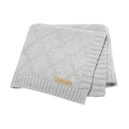 Mother holding a baby securely wrapped in a soft cotton swaddle, promoting bonding & comfort