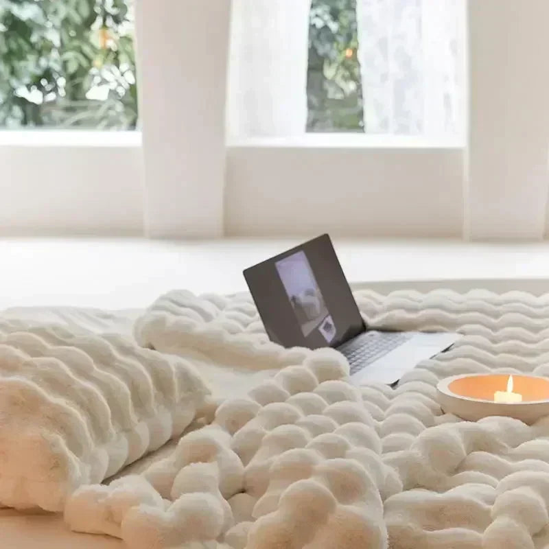 Beige & white faux fur throw blanket draped on a sofa. Ultra soft & cozy, ideal for a warm, inviting living room.