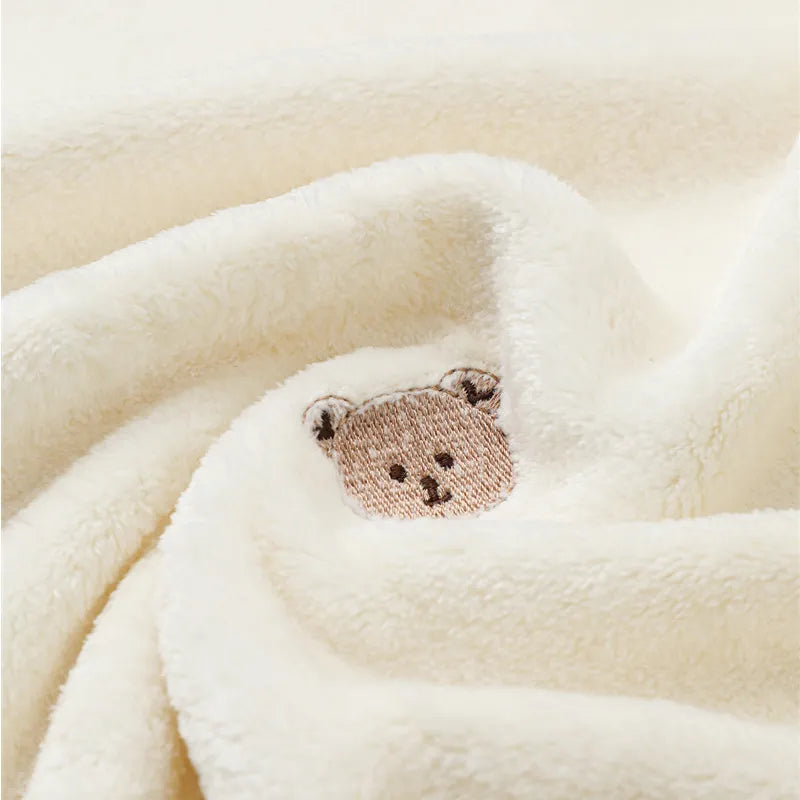 Ultra-soft fleece baby blanket draped over a crib. Adds warmth & style to nursery.