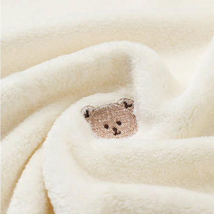 Ultra-soft fleece baby blanket draped over a crib. Adds warmth & style to nursery.