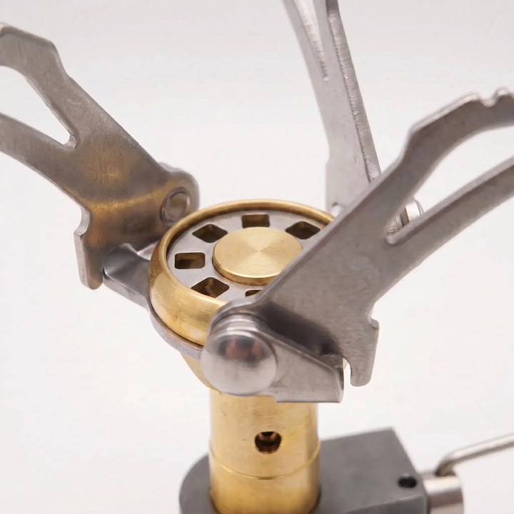 Folding ultralight camping stove and gas burner, essential for backpacking and efficient outdoor meals.