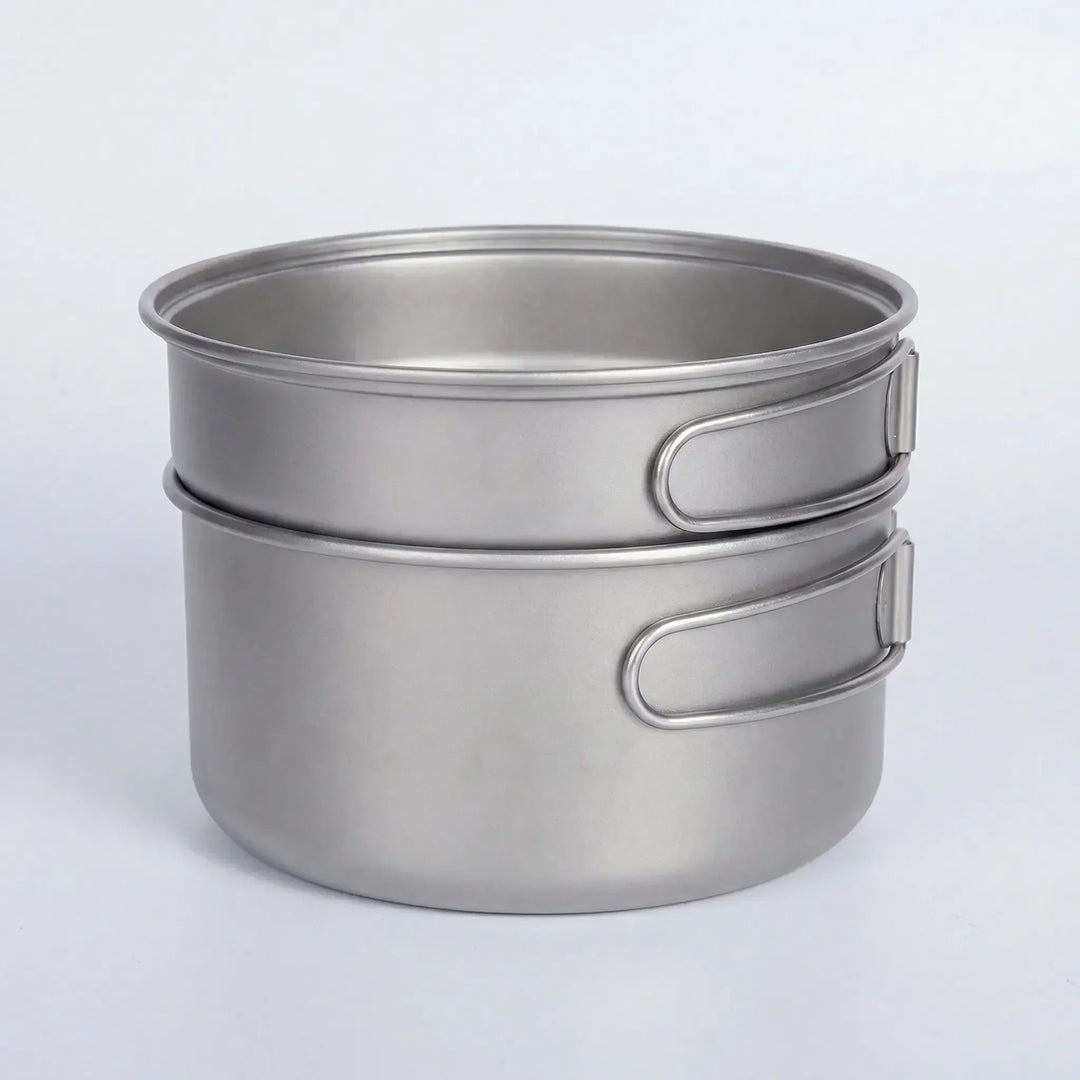Titanium backpacking cookware set with folding handles, ready for lightweight outdoor adventures & camping meals.