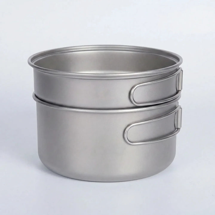 Titanium backpacking cookware set with folding handles, ready for lightweight outdoor adventures & camping meals.