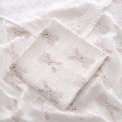 2-layer cotton muslin swaddle blanket spread out, showcasing its generous size for baby comfort