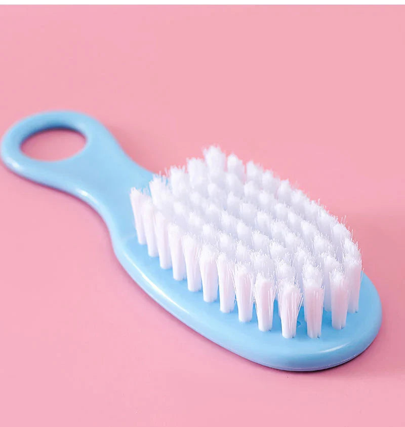 Ergonomic baby comb and brush designed for gentle infant hair care, part of a travel kit