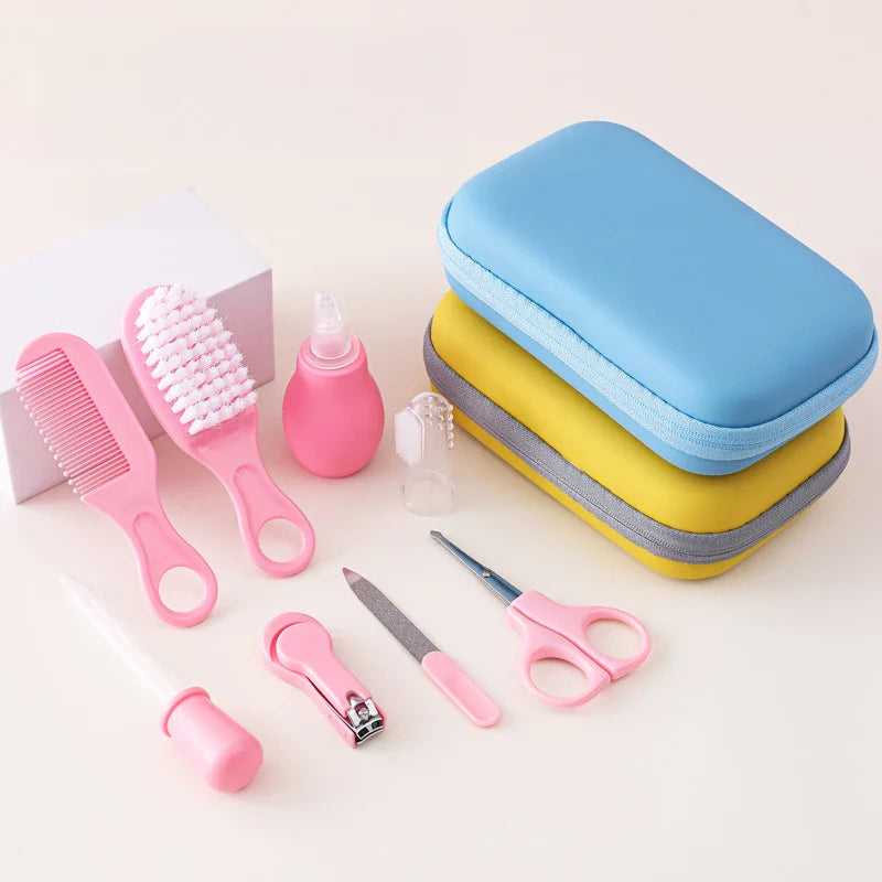 Pink zippered bag open revealing baby healthcare grooming kit with comb, brush, clippers