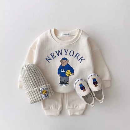 Adorable bear print detail on a unisex baby's hooded top, part of a two-piece outfit.