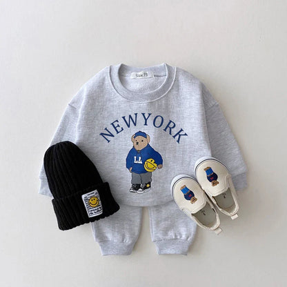 Cute letter bear print on a unisex baby hoodie and matching pants set in neutral colors.