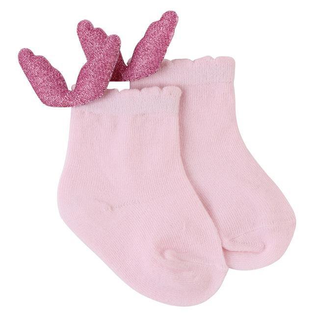 Toddler taking first steps in yellow anti-slip angel wings socks for extra grip