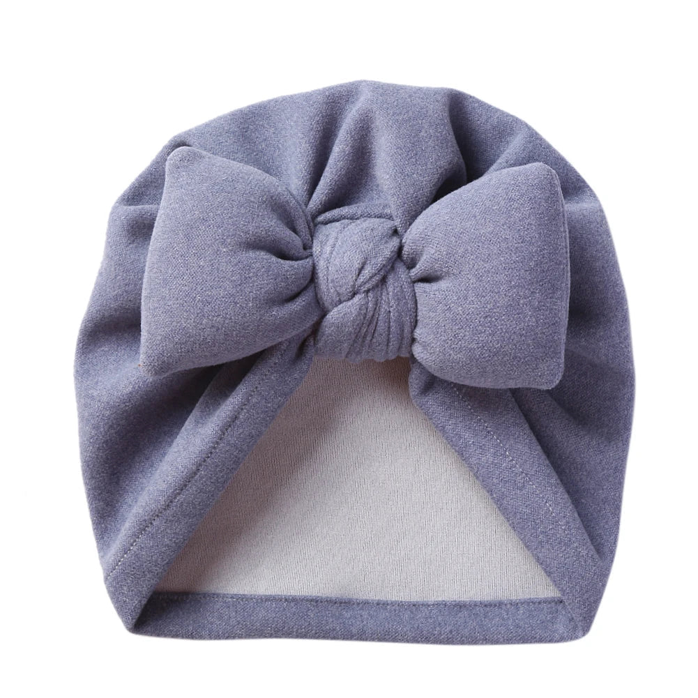 Front view of a unisex baby cashmere-like bow topknot bonnet, ideal newborn accessory