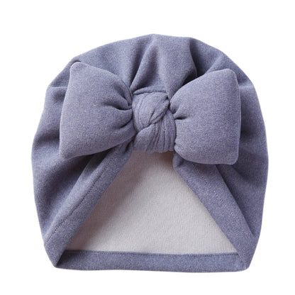 Front view of a unisex baby cashmere-like bow topknot bonnet, ideal newborn accessory