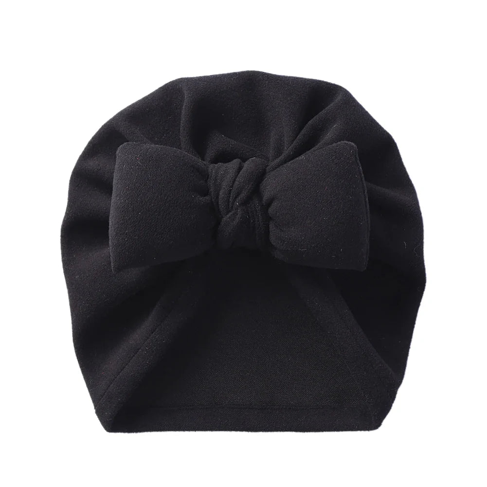 Folded cashmere-like bow topknot bonnet, showcasing its soft texture and quality