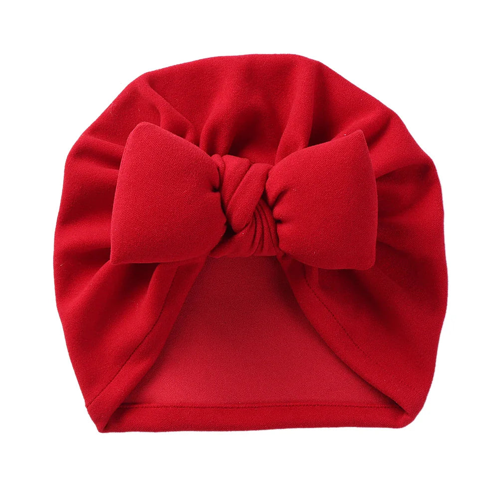 Soft and cozy cashmere blend baby bonnet with an elegant bow, perfect for baby's comfort