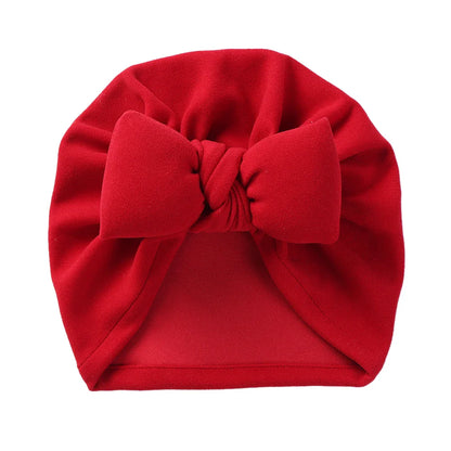Soft and cozy cashmere blend baby bonnet with an elegant bow, perfect for baby's comfort