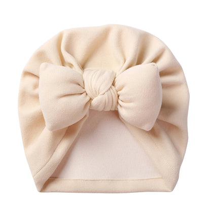 Cozy baby topknot bonnet, made from cashmere-like material, featuring an adorable bow