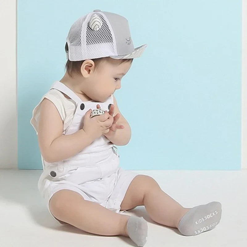 Cute infant anti-slip ankle socks made of soft cotton, essential for baby comfort & safety