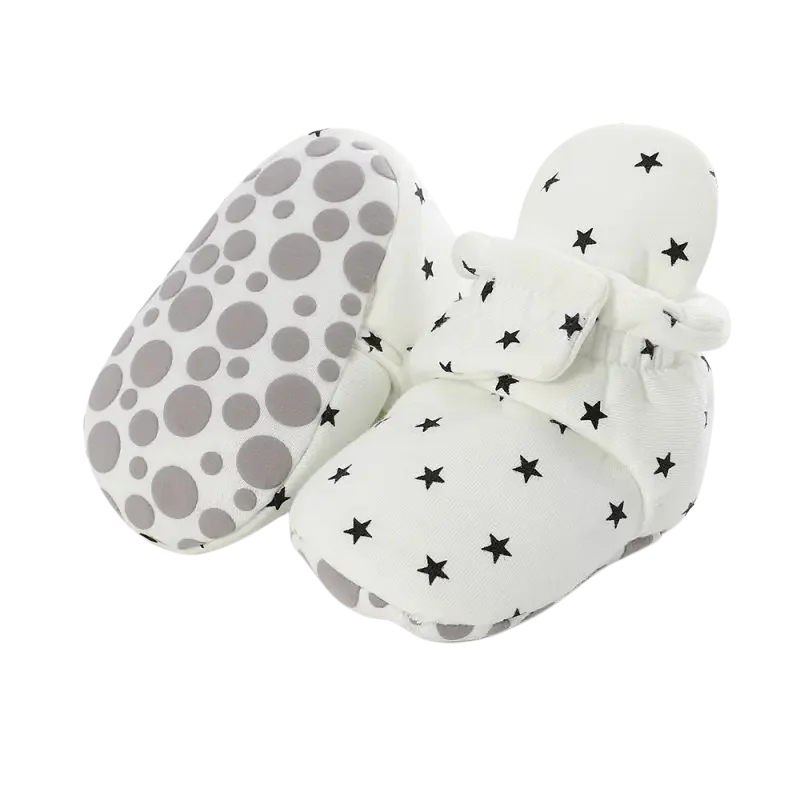 Close-up of soft cotton anti-slip baby booties, ideal infant shoes for new walkers, neutral color.