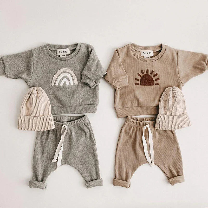 Detail of the ribbed texture on a unisex baby cotton clothing set, showing the quality of the soft fabric