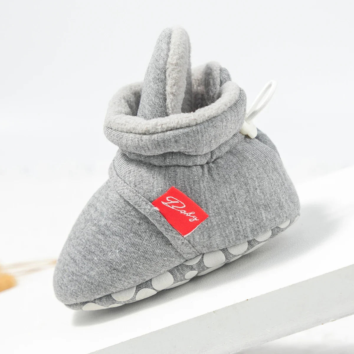 Pair of pink unisex baby first walker sock shoes with ribbed ankle cuff, top view.