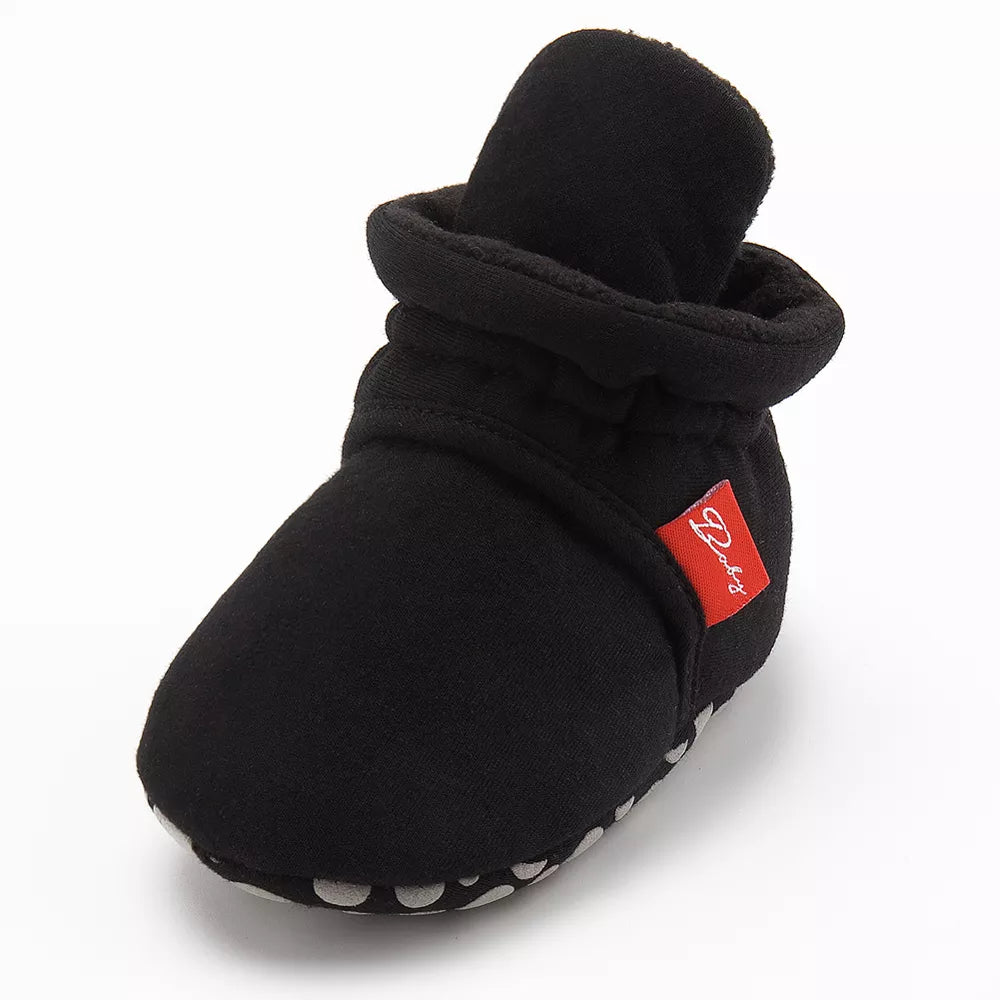 Detail of anti-slip silicone dots on the sole of a baby first walker sock shoe.