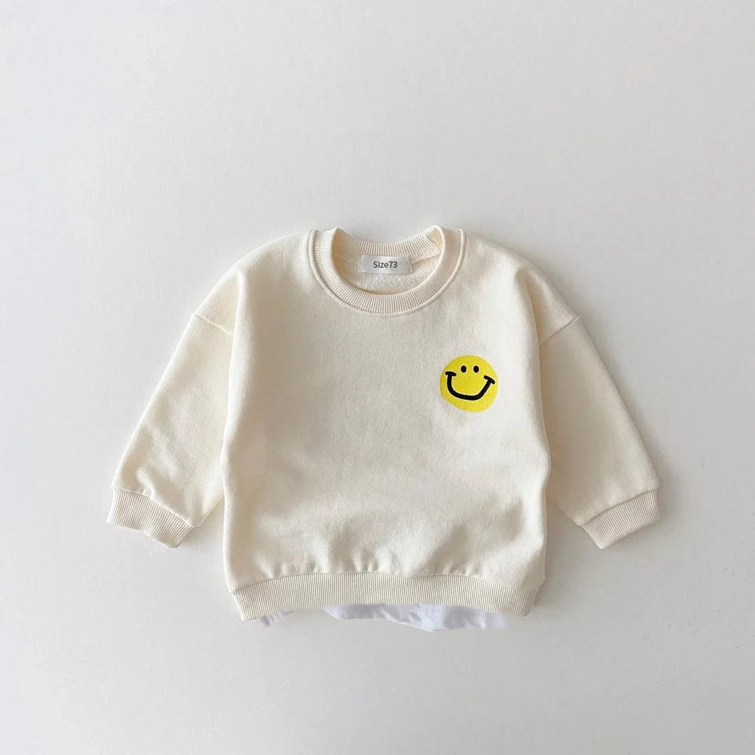 Unisex baby jogger set in vibrant yellow cotton, adorned with cheerful smiley faces, for infant play.